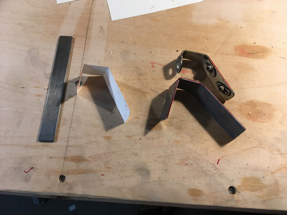 Old bracket, test bend, paper pattern, and strip prepared for the new bracket